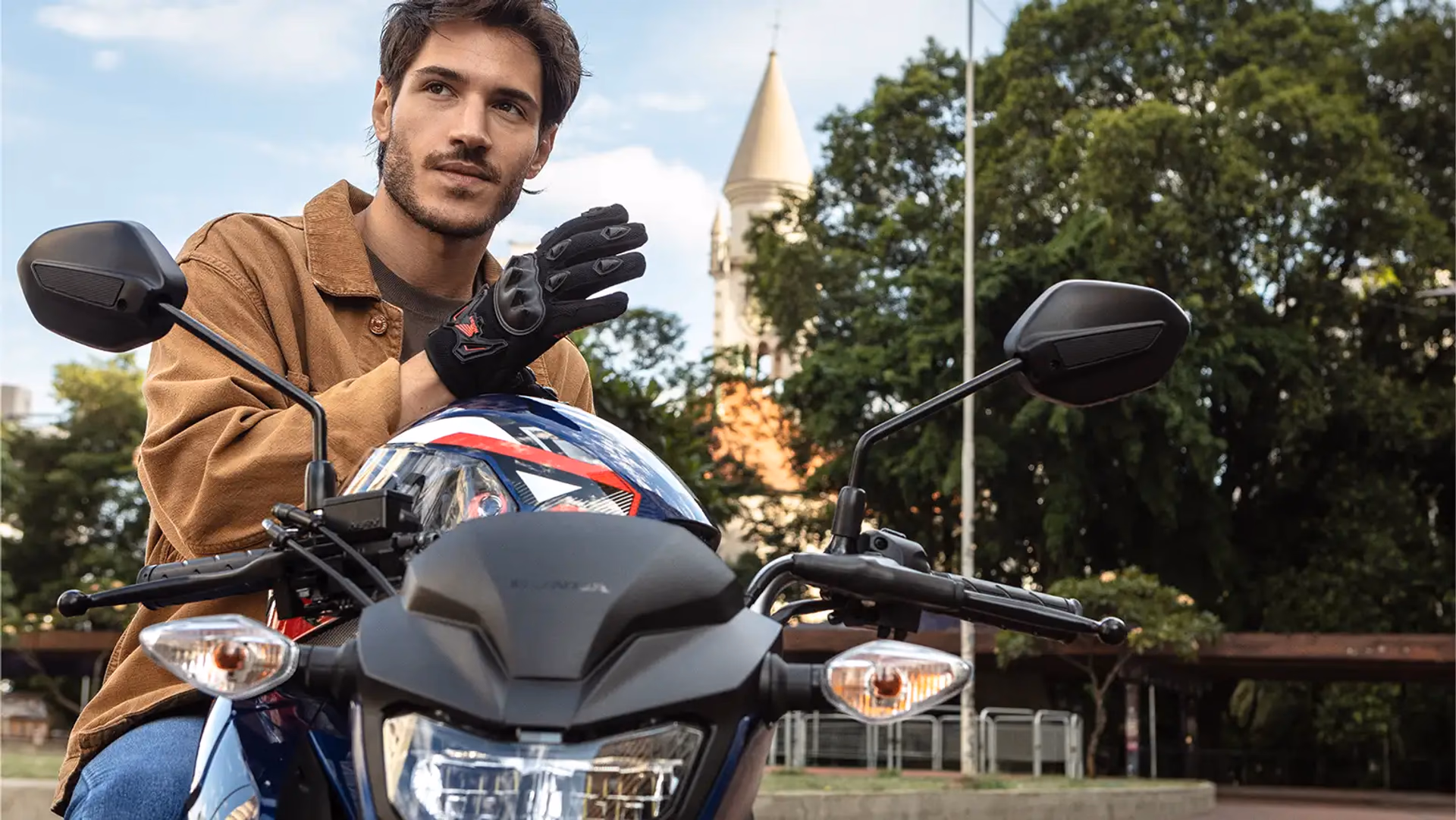 Homem usando luvas próximo à Honda CG 160 Fan - 7 de 9