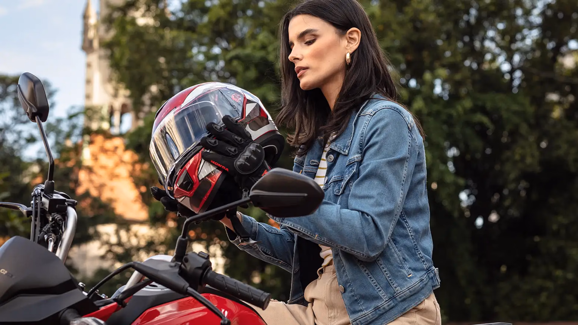Mulher observando capacete ao lado da Honda CG 160 Fan - 8 de 9